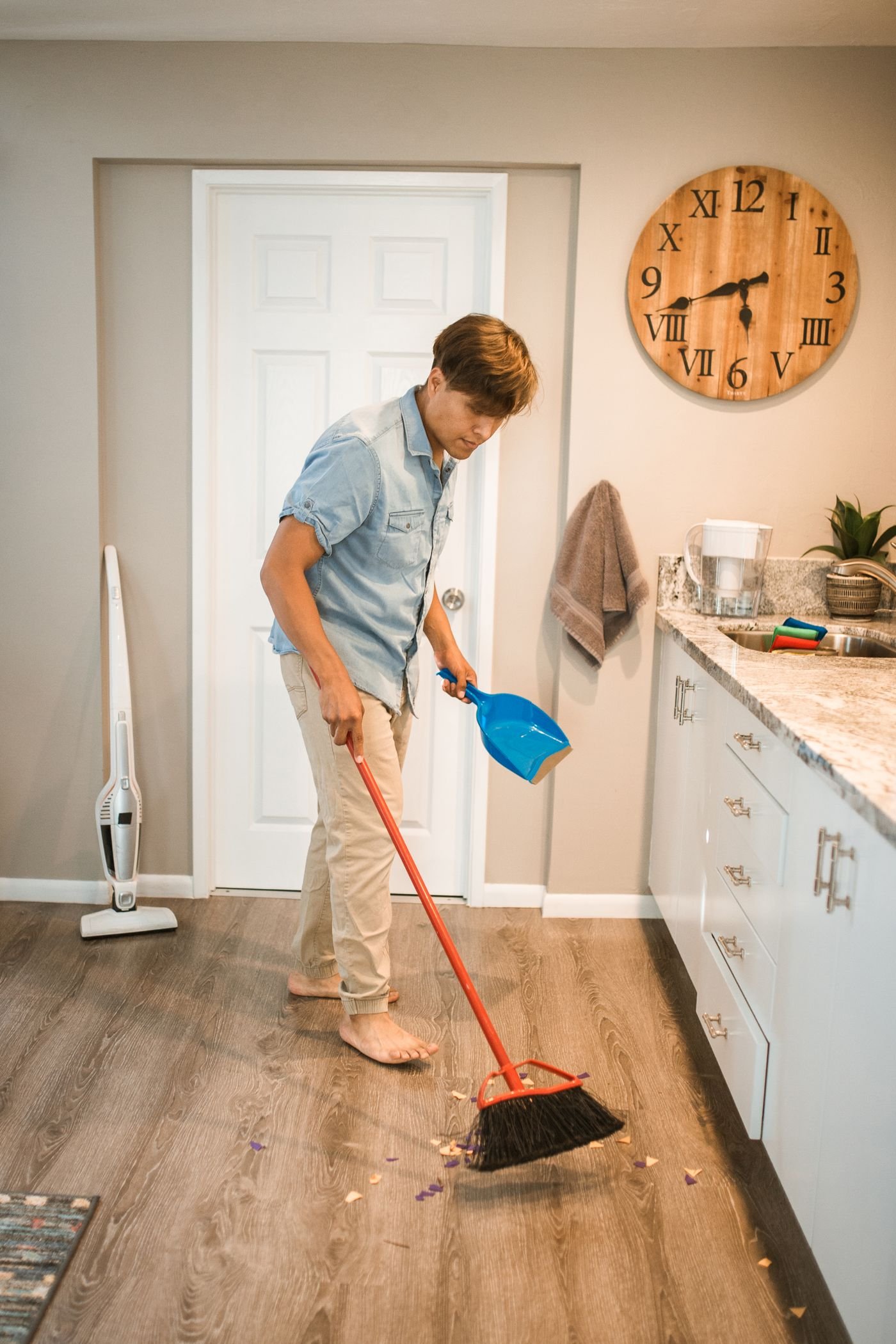 Cleaner sweeping a kitchen using eco-friendly methods